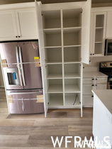 Pantry featuring hardwood flooring and microwave