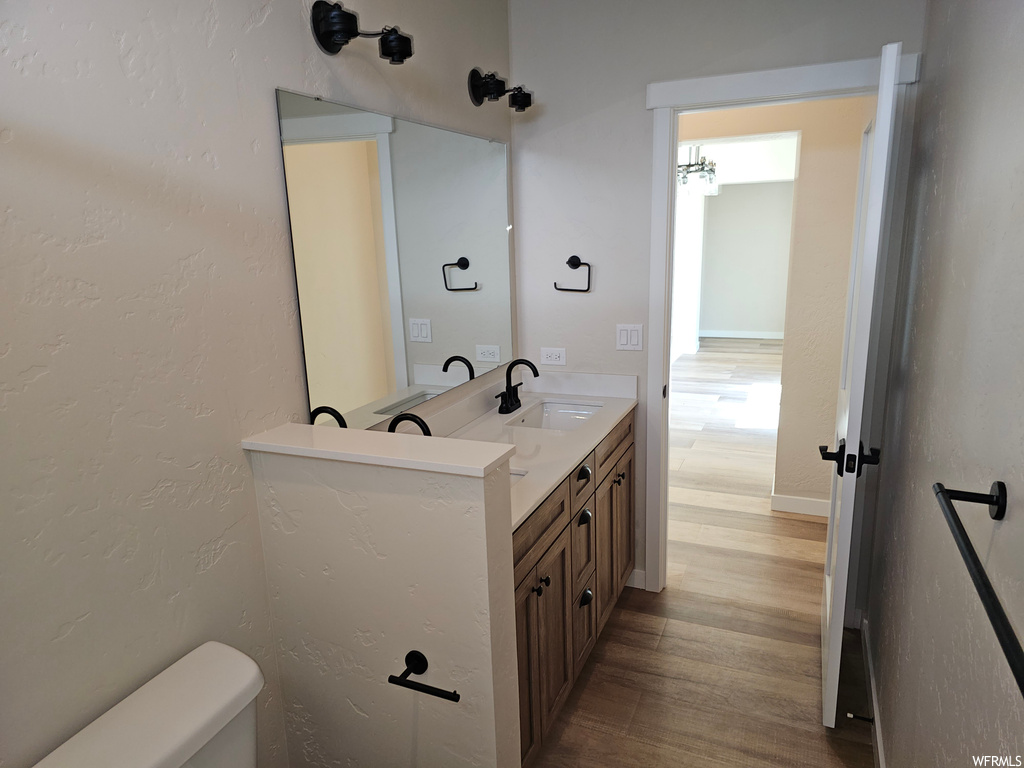Bathroom with hardwood flooring, mirror, and oversized vanity