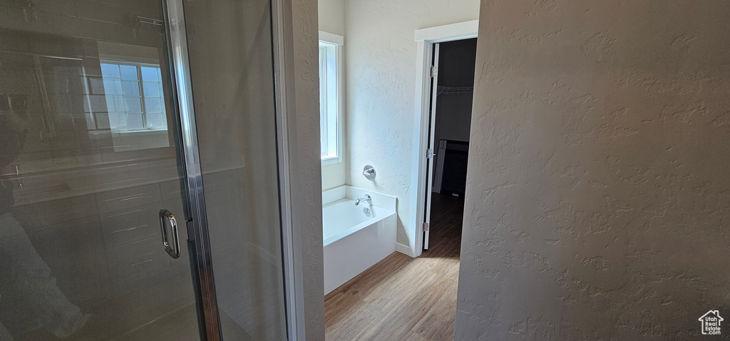 Bathroom featuring separate shower and tub and hardwood / wood-style floors