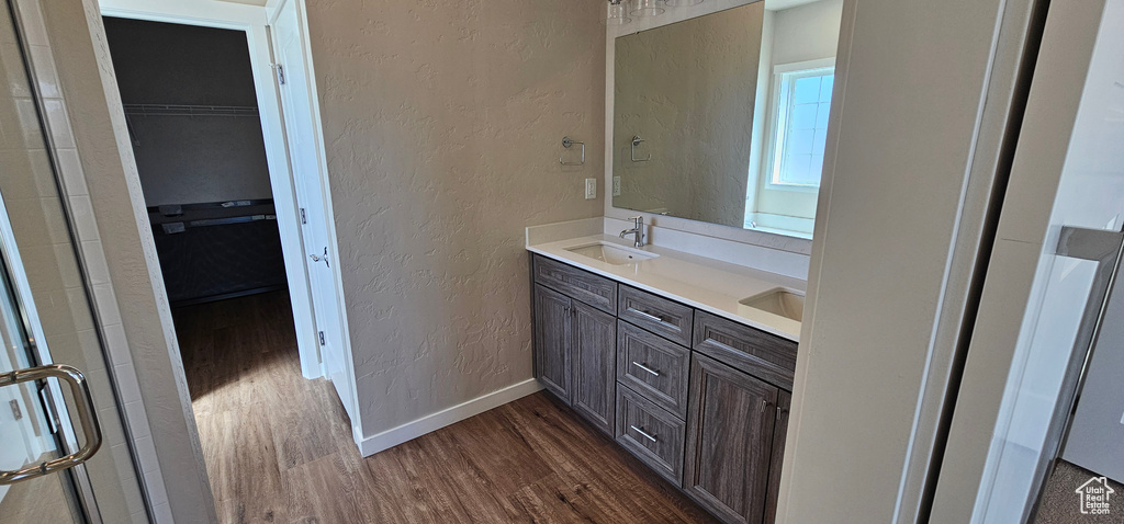Bathroom featuring double vanity, hardwood / wood-style flooring, and a shower with door