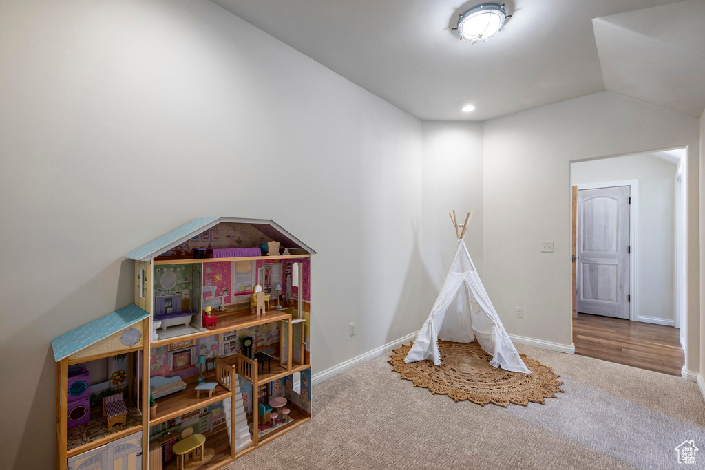 Game room with carpet flooring and vaulted ceiling