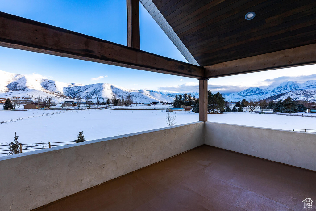 Snow covered back of property featuring a mountain view