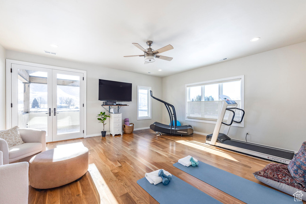 Exercise area with french doors, light hardwood / wood-style floors, and ceiling fan