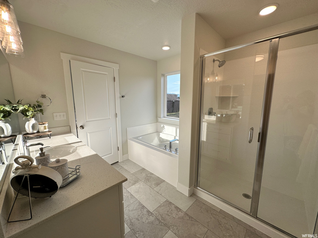 Bathroom with vanity, mirror, separate shower and tub enclosures, and light tile floors