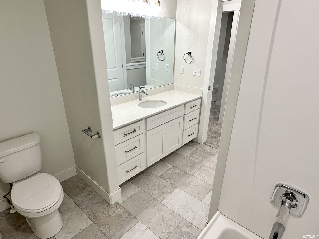 full bathroom with tile floors, shower / tub combination, mirror, vanity, and toilet