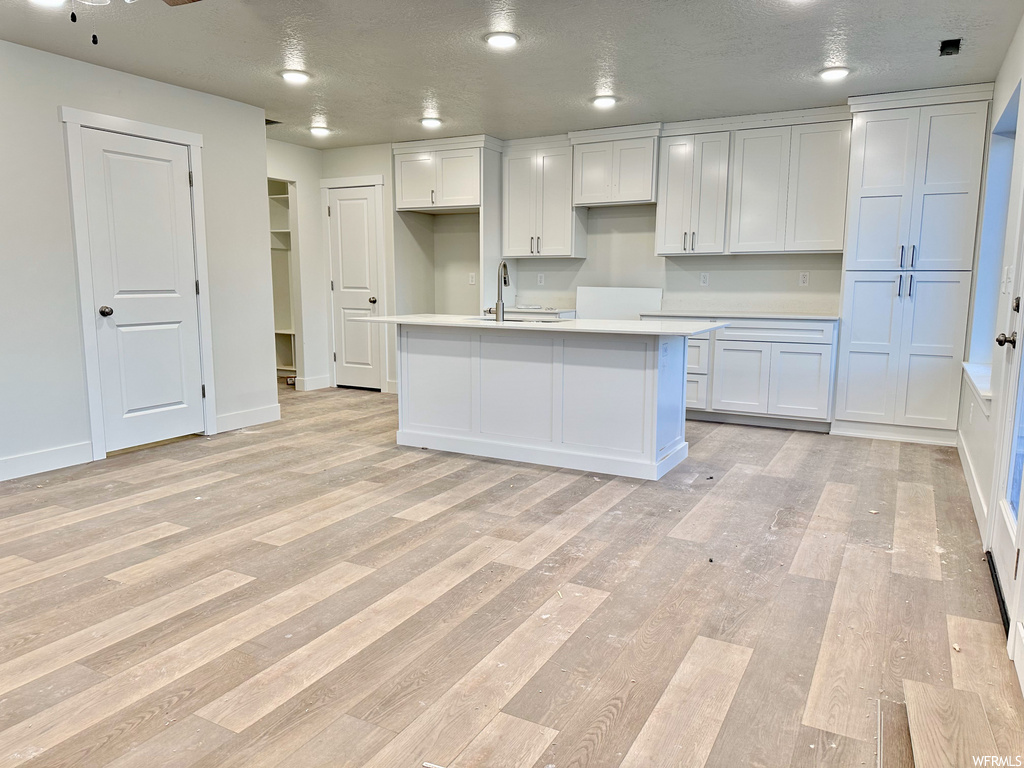 kitchen featuring white cabinetry, light countertops, and light hardwood floors