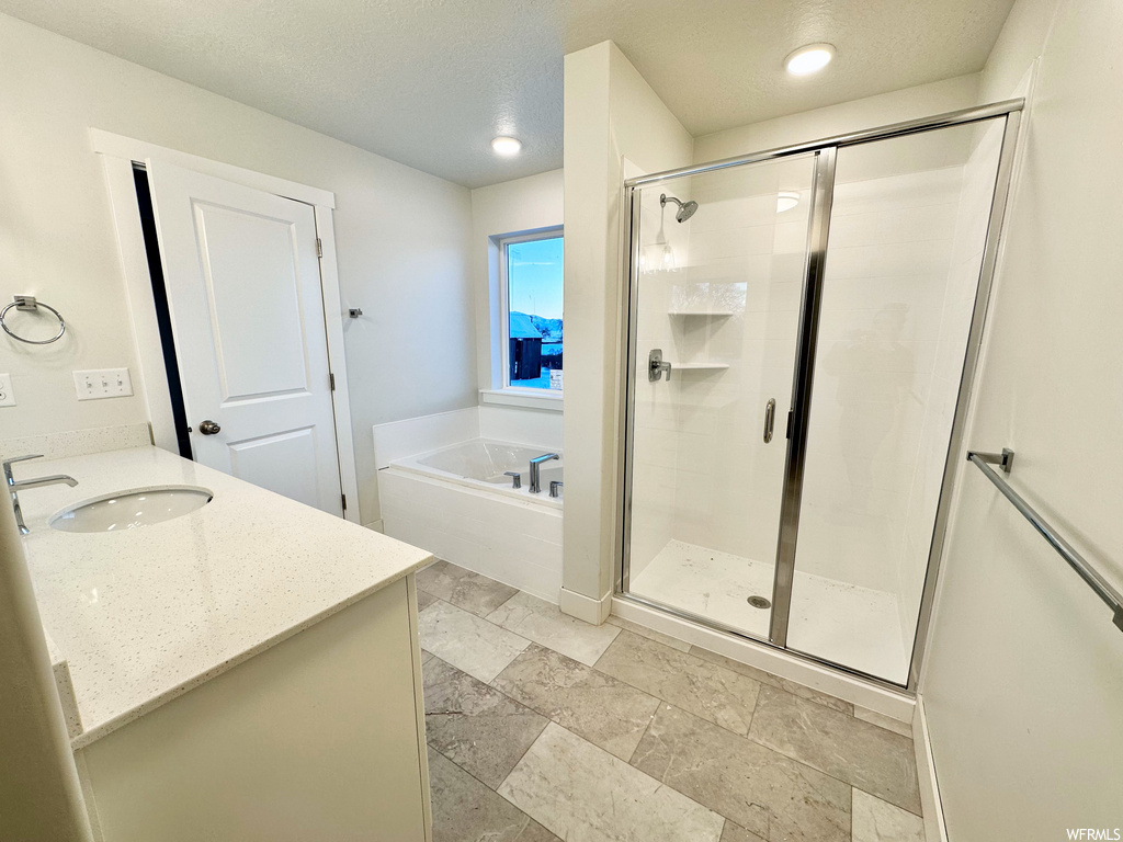 bathroom with tile flooring, vanity, and separate shower and tub enclosures