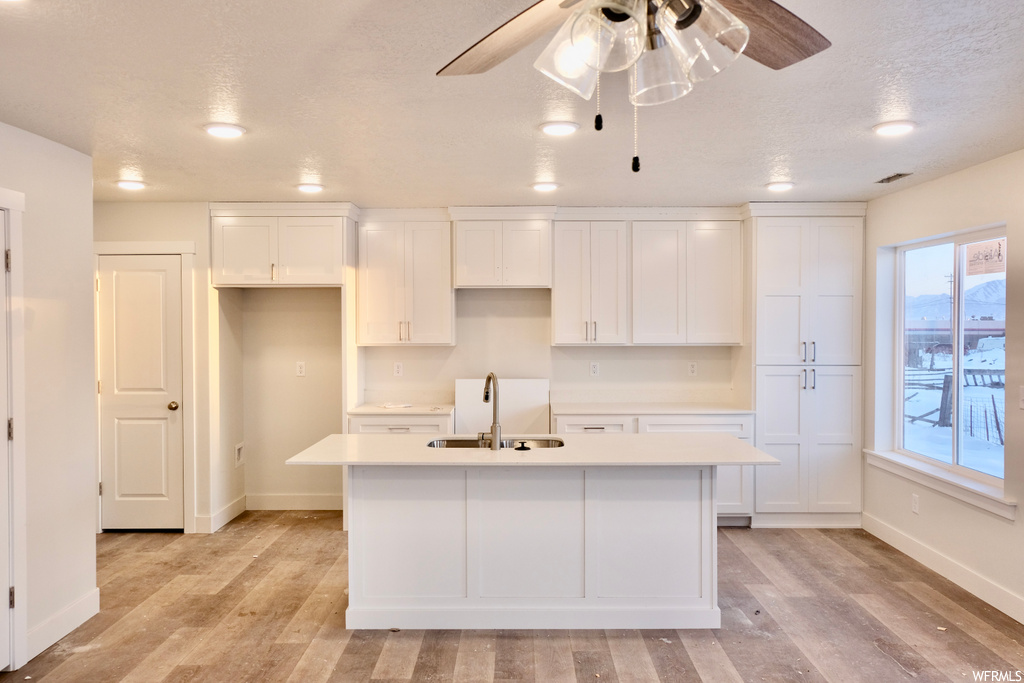 kitchen featuring light countertops, white cabinetry, and light parquet floors