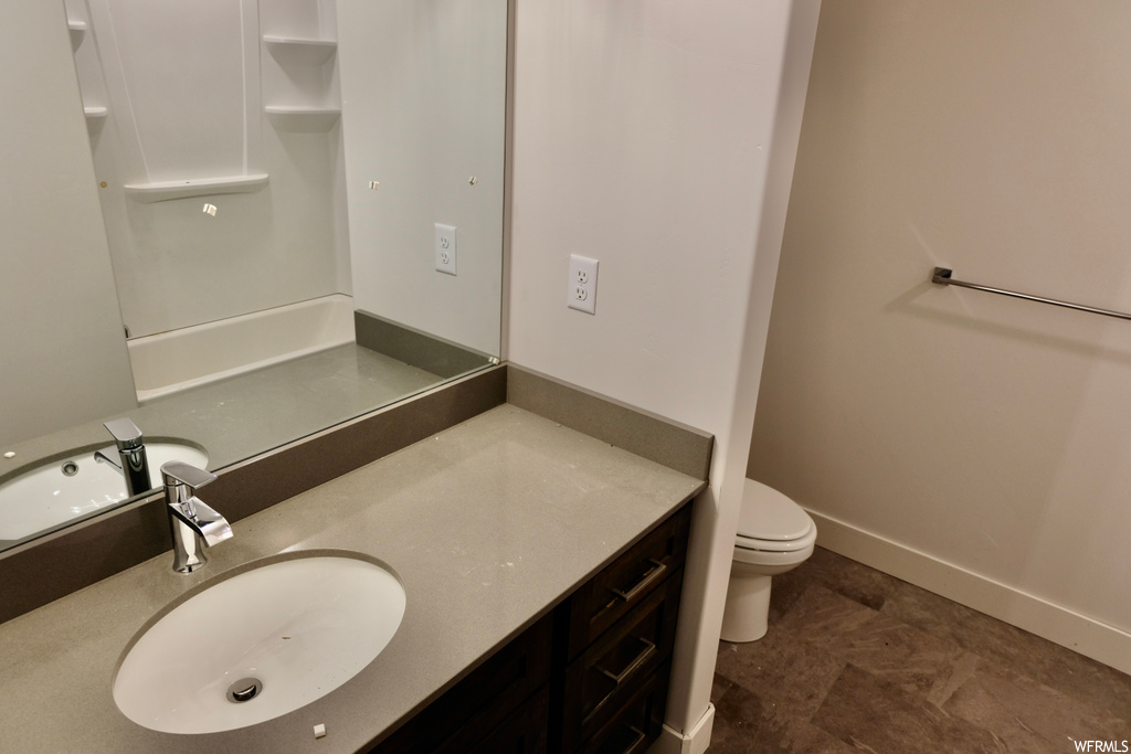 half bathroom featuring tile flooring, mirror, toilet, and vanity
