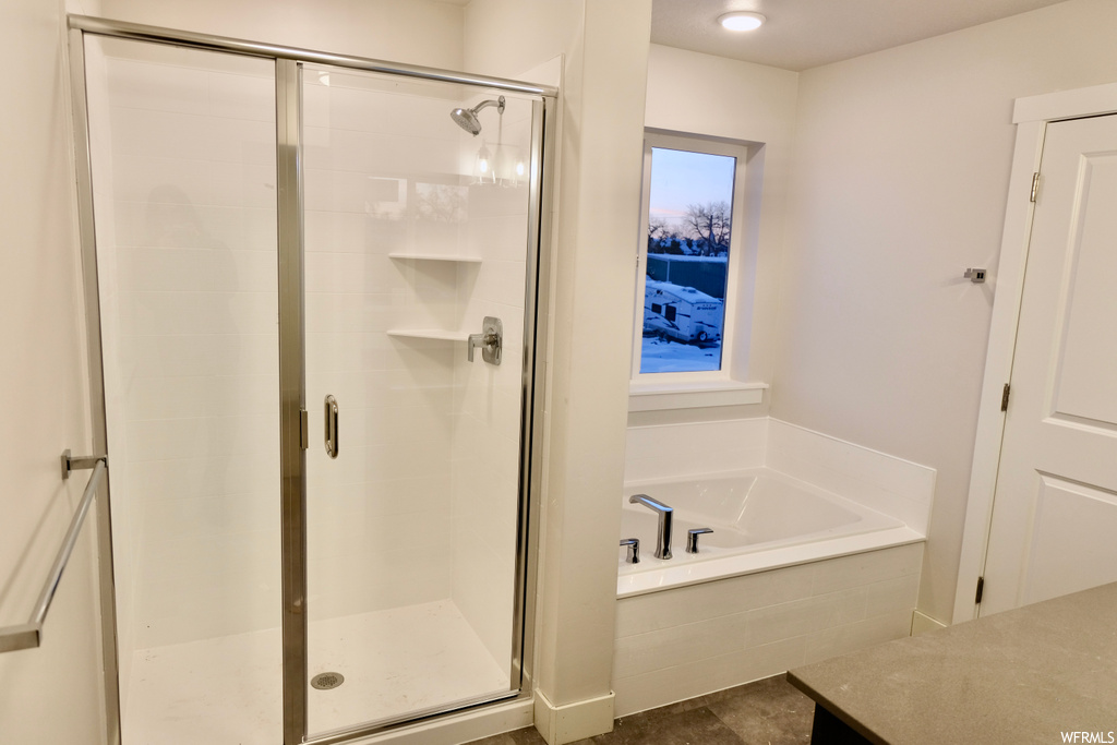 bathroom featuring natural light, tile flooring, and independent shower and bath