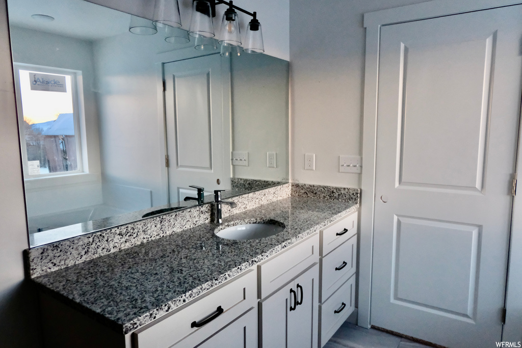 bathroom featuring mirror, vanity, and a bathtub