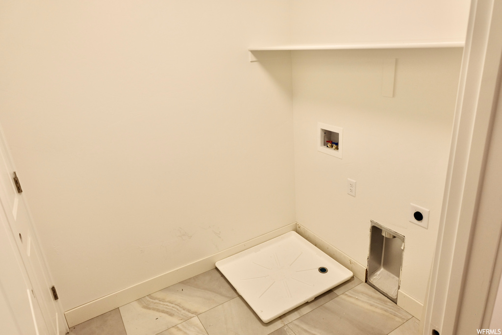 clothes washing area featuring tile flooring