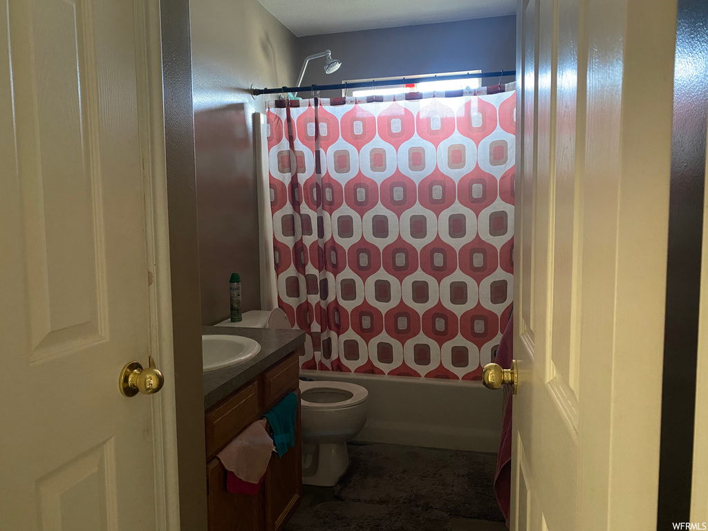 full bathroom with shower curtain, bathtub / shower combination, toilet, and vanity