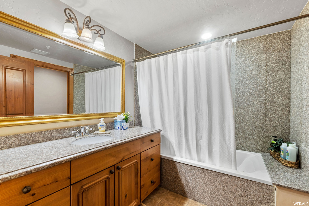 bathroom with tile floors, shower / bathing tub combination, oversized vanity, mirror, and shower curtain
