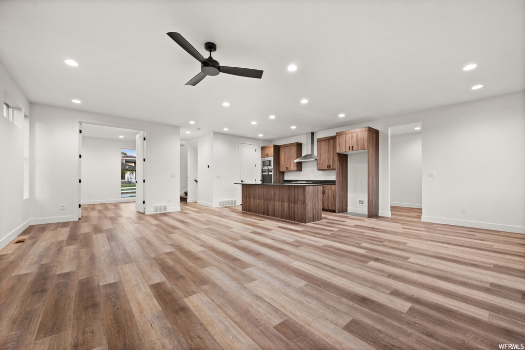 Living room featuring ceiling fan and light hardwood floors