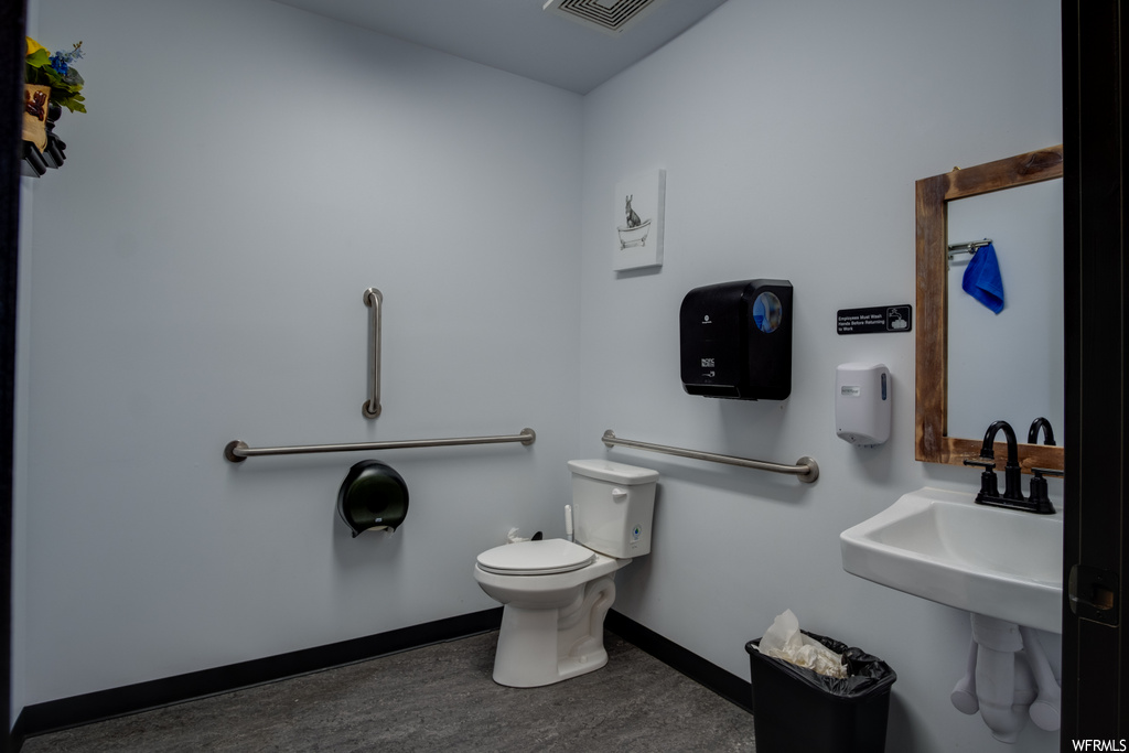 half bathroom featuring mirror, sink, and toilet
