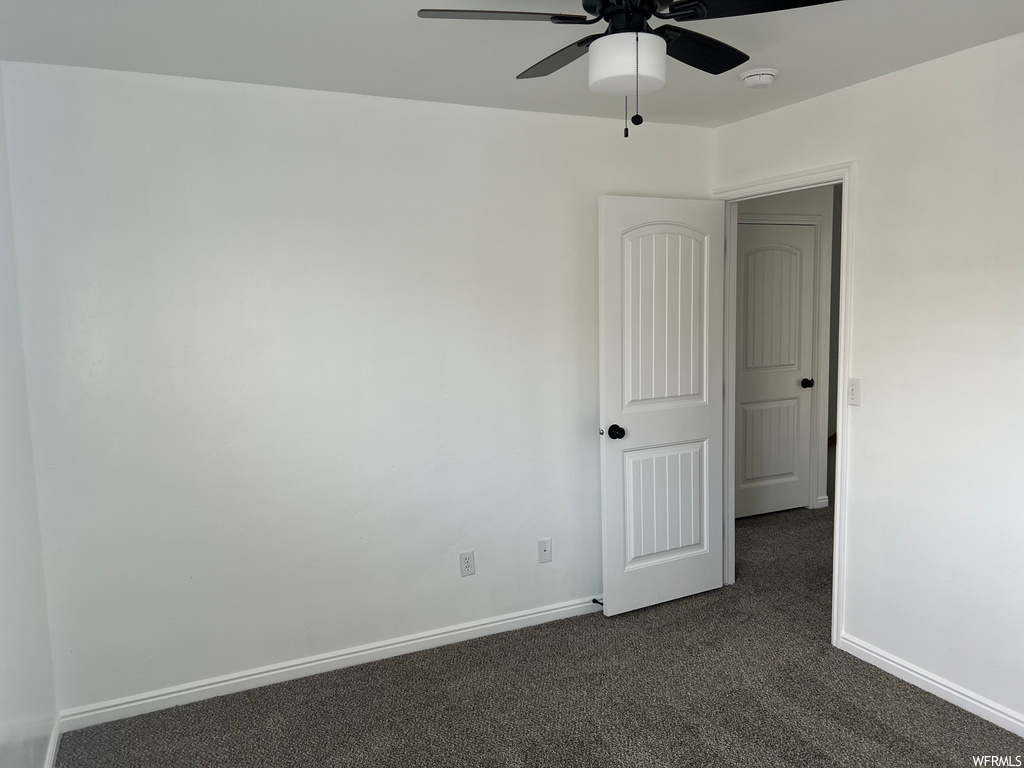 carpeted empty room with a ceiling fan