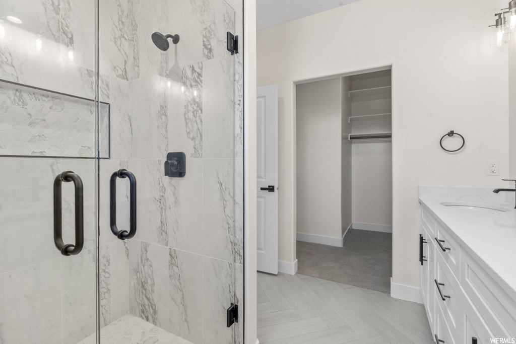 bathroom with hardwood floors, vanity, and enclosed shower