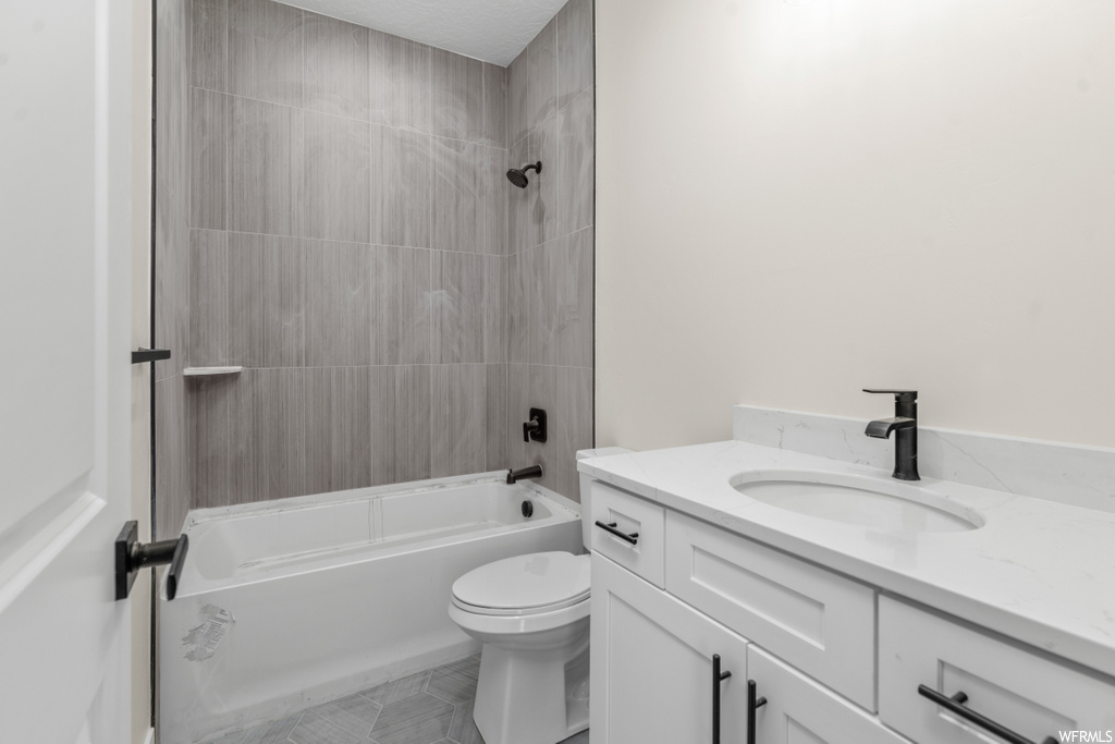 full bathroom featuring tile flooring, shower / bath combination, vanity, and toilet