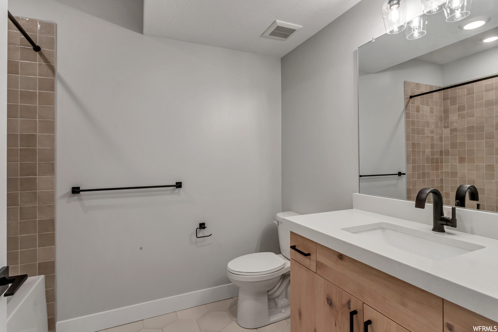 Full bathroom featuring tile floors, toilet, shower / tub combo with curtain, and vanity with extensive cabinet space