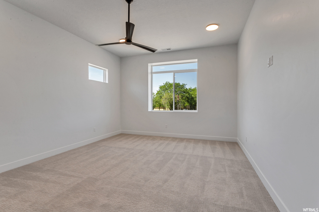Unfurnished room with ceiling fan and light colored carpet