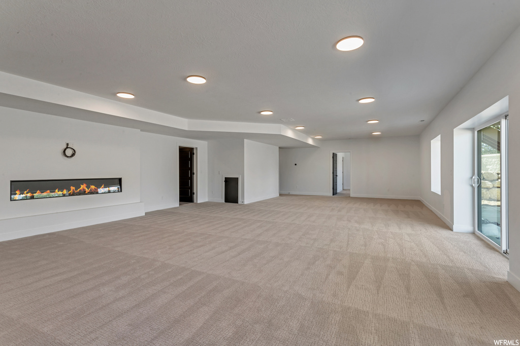 Unfurnished living room featuring light carpet