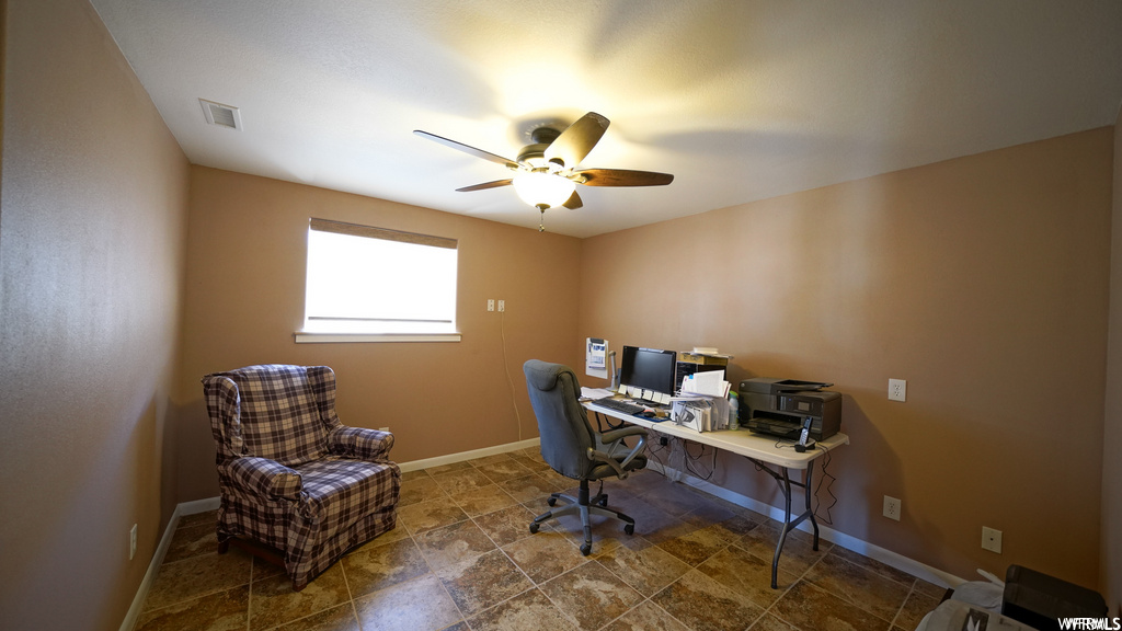home office featuring tile flooring, natural light, a ceiling fan, and TV