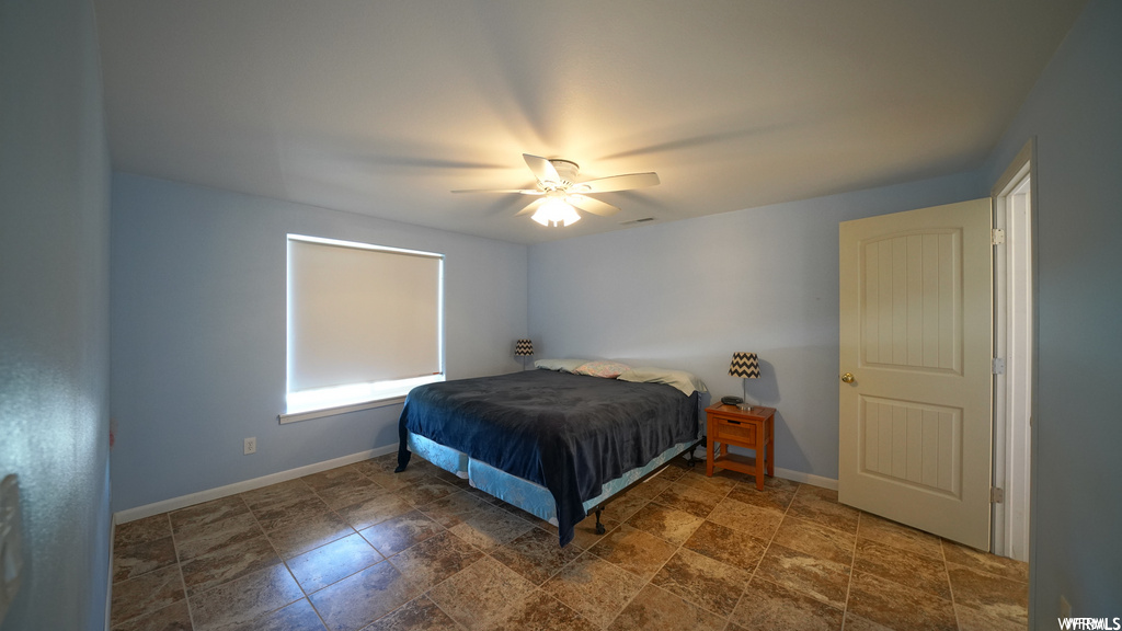 tiled bedroom featuring a ceiling fan