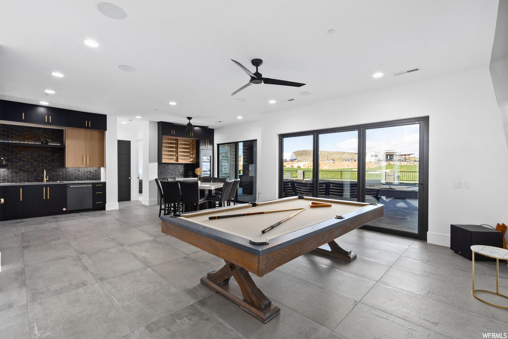 recreation room featuring natural light, tile flooring, and a ceiling fan