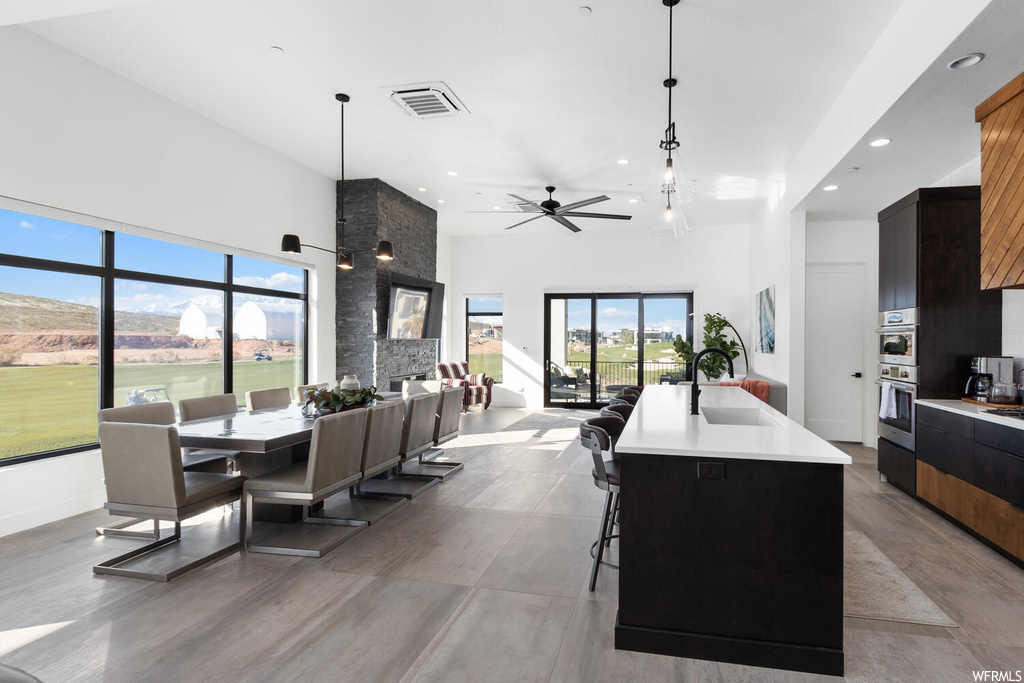 interior space featuring a kitchen bar, a ceiling fan, and a healthy amount of sunlight