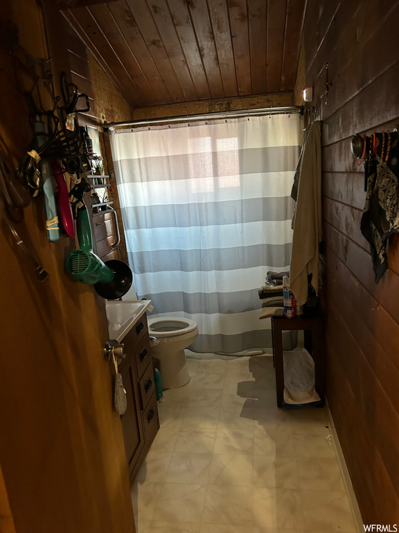 bathroom featuring tile floors, shower curtain, and toilet