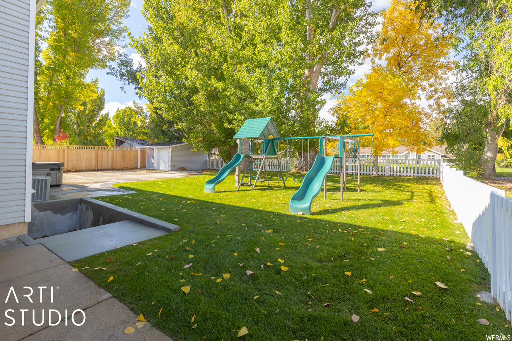View of yard with a patio area, a playground, and an outdoor structure