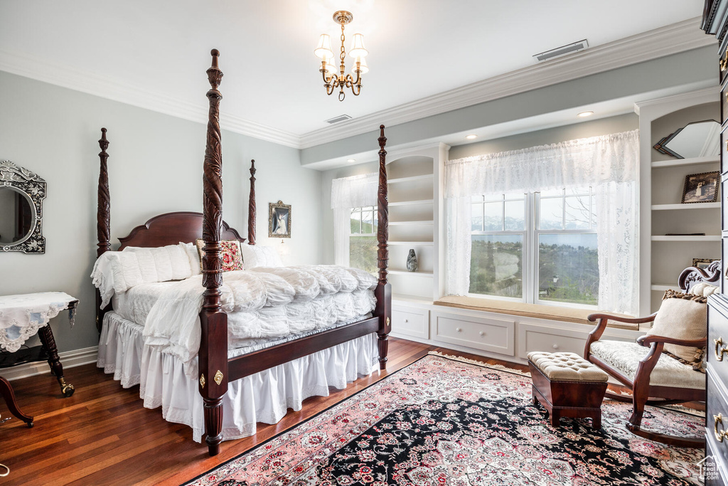 Bedroom featuring crown molding, a notable chandelier, and wood-type flooring
