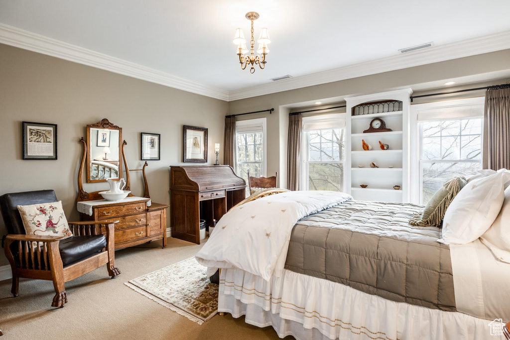 Carpeted bedroom featuring an inviting chandelier and crown molding