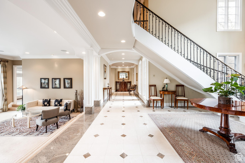 Tiled entrance foyer with a healthy amount of sunlight, crown molding, and ornate columns