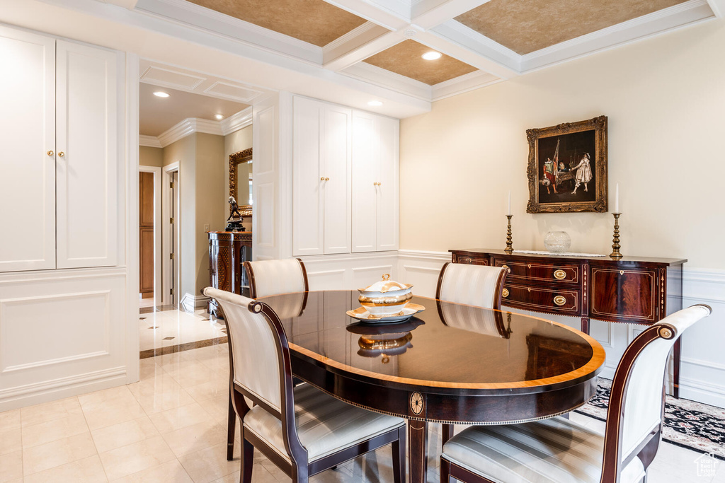 Tiled dining space featuring coffered ceiling, beam ceiling, and crown molding