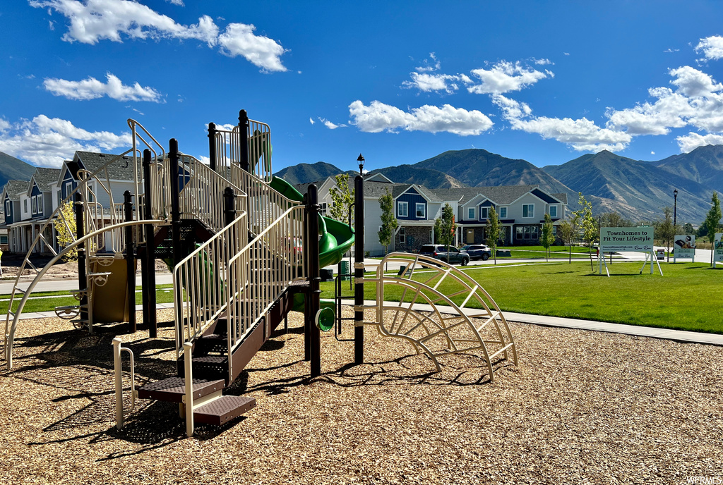 view of jungle gym featuring a yard and a mountain view