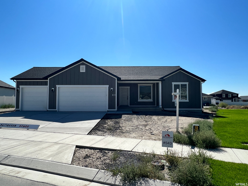 View of front of property featuring garage and a front lawn