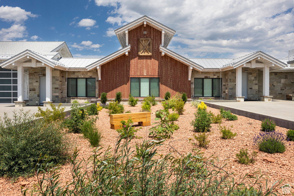 View of front of home with metal roof, stone siding, and a standing seam roof