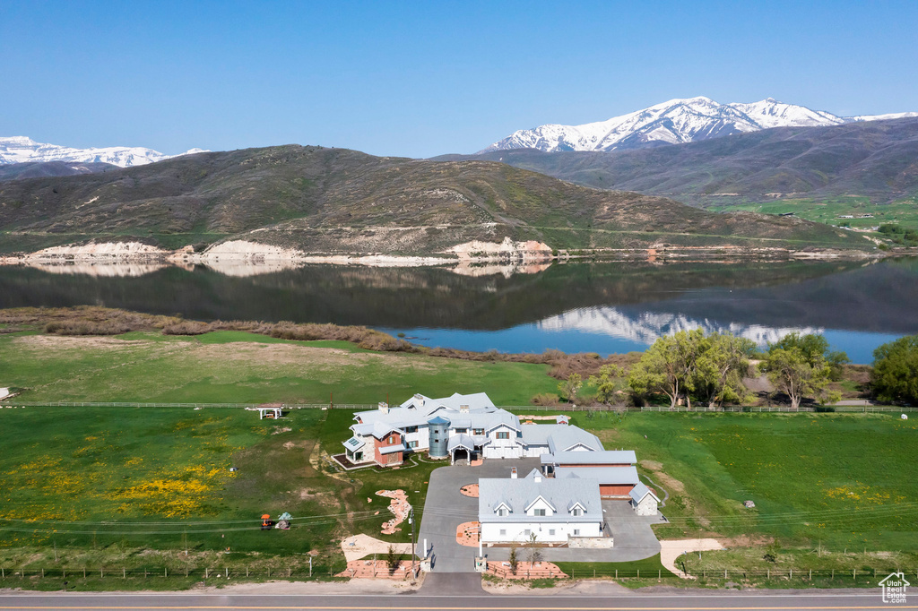 Aerial view of property and surrounding area featuring a water and mountain view