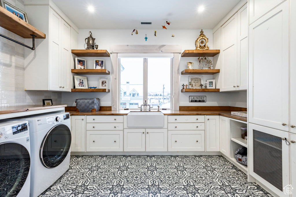 Washroom featuring independent washer and dryer, cabinet space, recessed lighting, and light floors