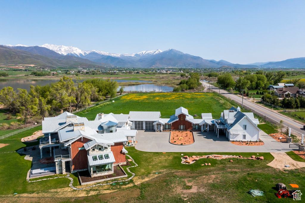 Aerial view of property and surrounding area featuring a water and mountain view