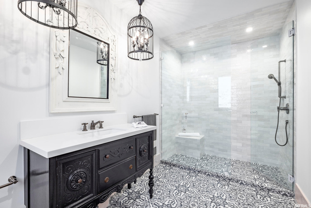 Bathroom with vanity, a notable chandelier, and walk in shower