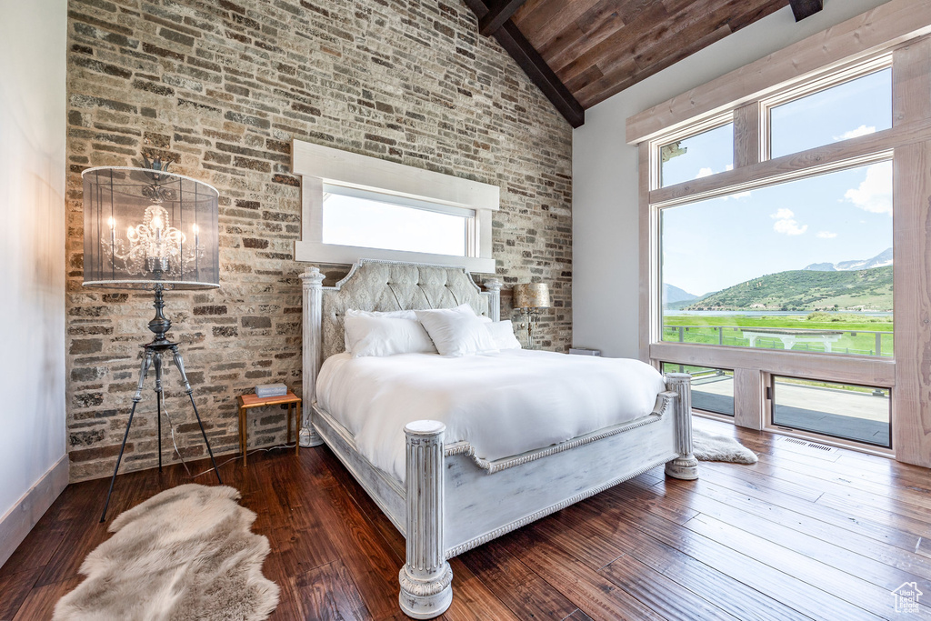 Bedroom featuring high vaulted ceiling, a chandelier, wood-type flooring, beamed ceiling, and access to outside