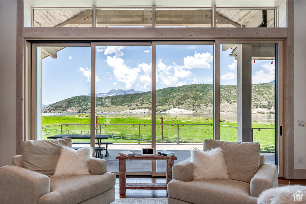 Living room with lofted ceiling, a mountain view, and wood finished floors