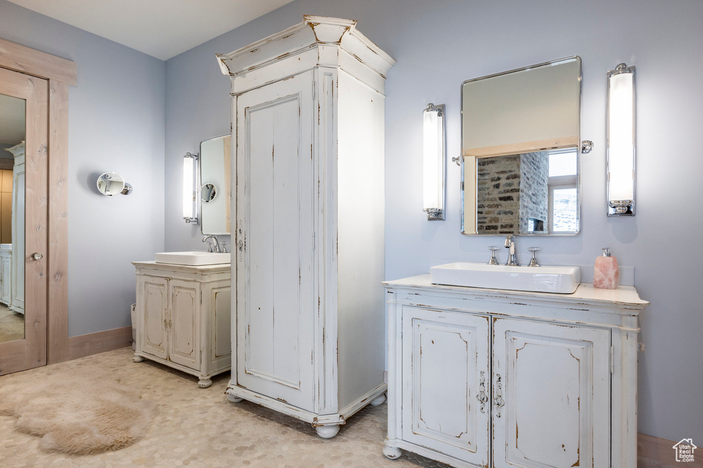 Bathroom featuring two vanities and baseboards