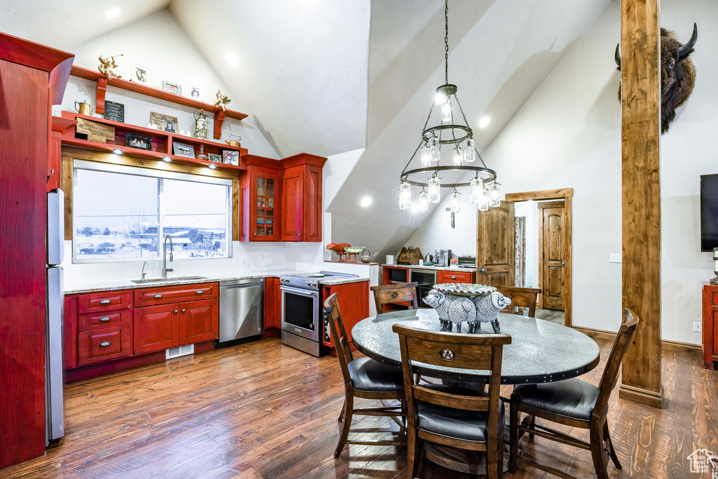 Dining area with high vaulted ceiling, dark wood finished floors, and recessed lighting