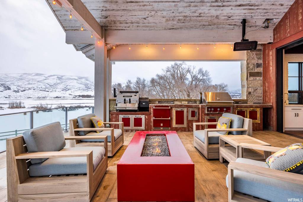 Snow covered patio featuring grilling area, a mountain view, area for grilling, and an outdoor living space with a fire pit