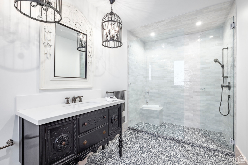 Full bath with tiled shower, a chandelier, vanity, and recessed lighting