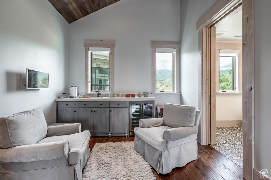 Living area with dark wood finished floors, vaulted ceiling, and wood ceiling